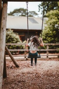 young child using sensory swing for vestibular input autism calming at home