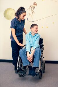 therapist supporting child in wheelchair with sensory tools autism cerebral palsy multiple disabilities