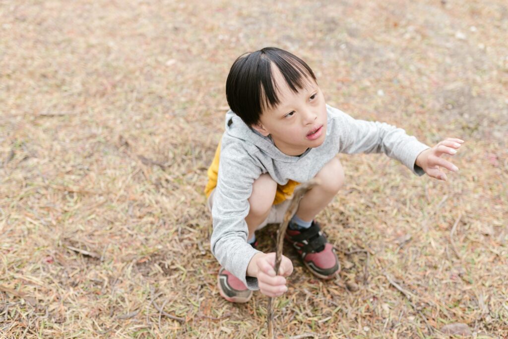 Boy with Down syndrome exploring outdoors, representing autistic children benefiting from sensory tools and real-world research