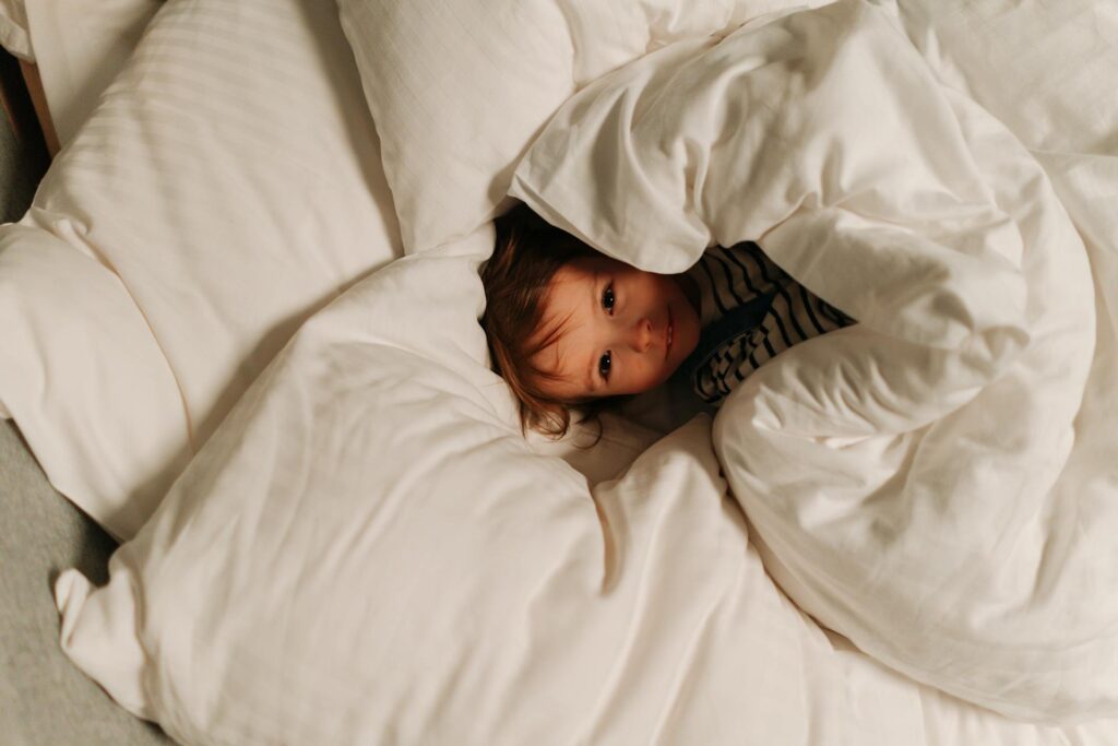 Young child bundled snugly in soft blankets, showing the comfort and calming effect of deep pressure tools for autism