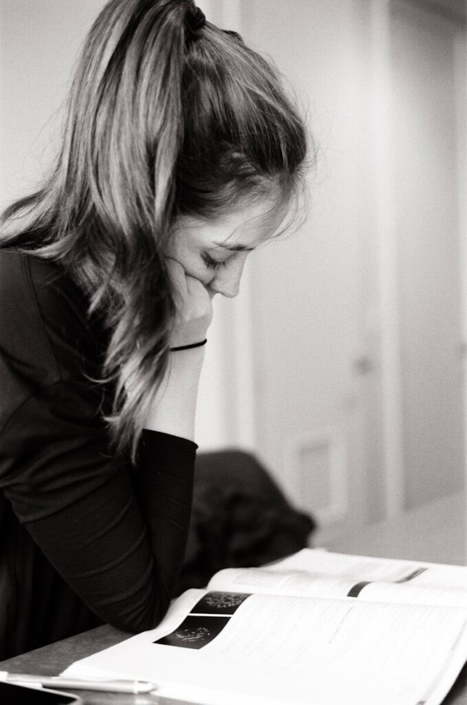 Tired mom writing notes to prepare for talking to school about sensory needs with autism scripts