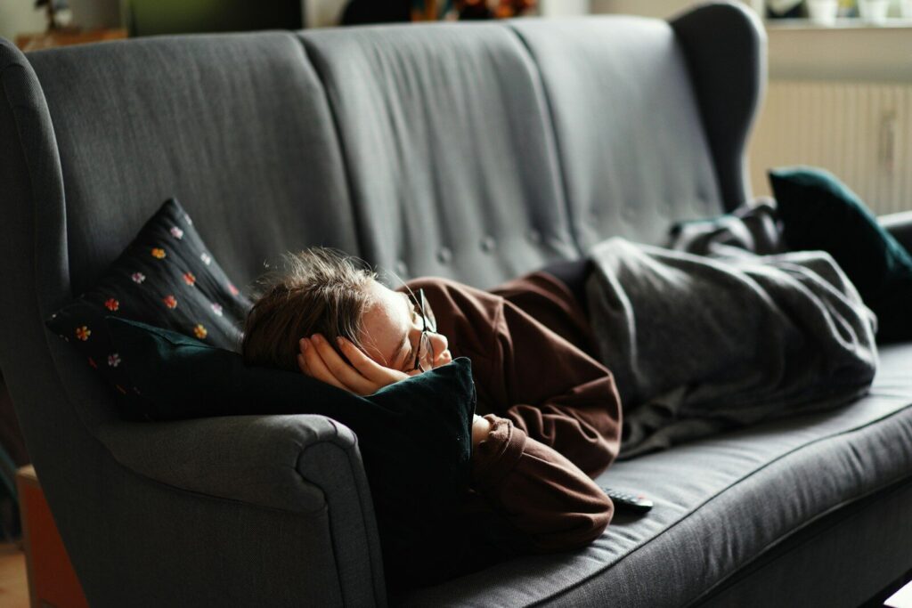Autistic child resting on couch during autism evening decompression routine after school