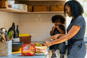 autism gut health connection - mother and child cooking healthy food together in kitchen