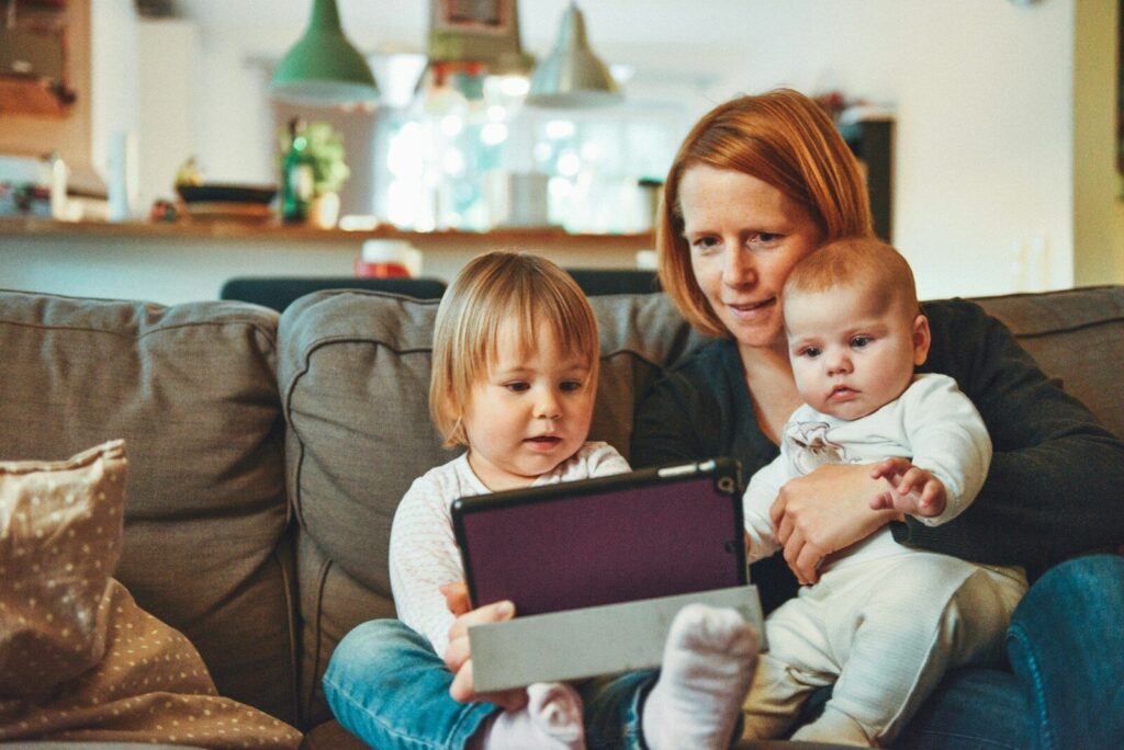 Parent and autistic child engaging in telehealth therapy session at home on a tablet