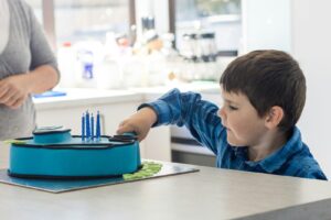 autistic child playing drum during music therapy session exploring music therapy autism benefits